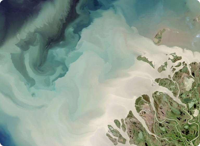 Aerial view of pale blue coastal waters and land