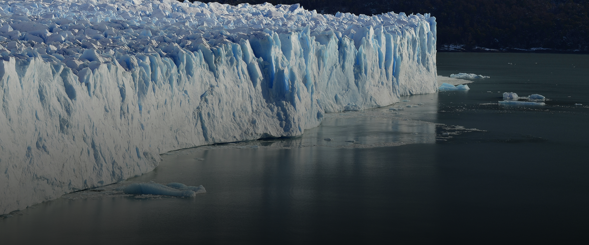 Glacier meeting a dark lake